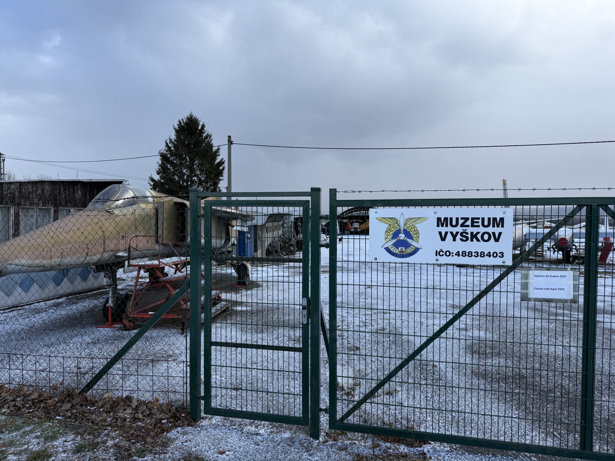 Das Bild zeigt das Museum Vysov in Tschechien, eingebettet in eine verschneite Winterlandschaft. Das Museum widmet sich der regionalen Geschichte und erinnert an bedeutende Persönlichkeiten und Ereignisse der Gegend. Es bietet Einblicke in das kulturelle und historische Erbe, darunter die Luftfahrtgeschichte, was durch die Installation eines Denkmals symbolisiert wird. Umgeben von gepflegten Grünflächen, die im Winter schneebedeckt sind, bietet das Museum eine harmonische Verbindung von Bildung und Natur. Im Hintergrund sind traditionelle Gebäude sowie malerische Hügel zu sehen.